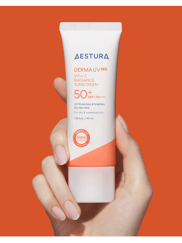 AESTURA Derma UV 365 Vita-C Radiance Sunscreen 40ml SPF50+ PA++++ in hand on orange background