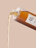 Beauty of Joseon Ginseng Essence Water 150ml pouring from the bottle on a soft background.