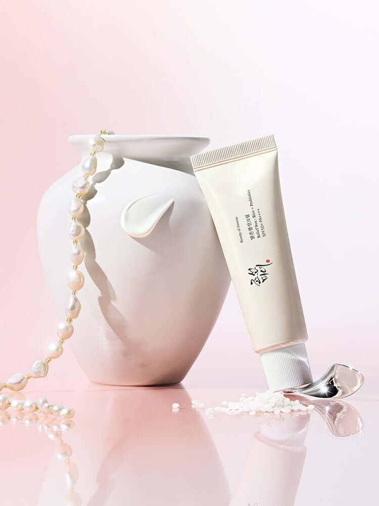 Beauty of Joseon Relief Sun : Rice + Probiotics 50ml SPF50+/PA++++ tube next to a decorative vase with pearls.