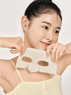 A young woman holding a BIODANCE Radiant Vita Niacinamide Real Deep Mask, preparing to apply it to her face.