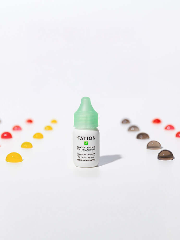 FATION Nosca9 Trouble Toning Ampoule 15ml bottle on a white background with colorful drops around it.
