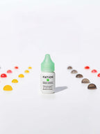 FATION Nosca9 Trouble Toning Ampoule 15ml bottle on a white background with colorful drops around it.