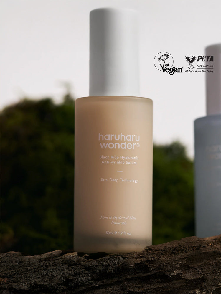 HARUHARU WONDER Black Rice Hyaluronic Anti-wrinkle Serum 50ml in a serene outdoor setting, showcasing its vegan certification.