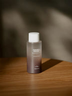 HARUHARU WONDER Black Rice Hyaluronic Toner 150ml on a wooden surface with soft lighting.