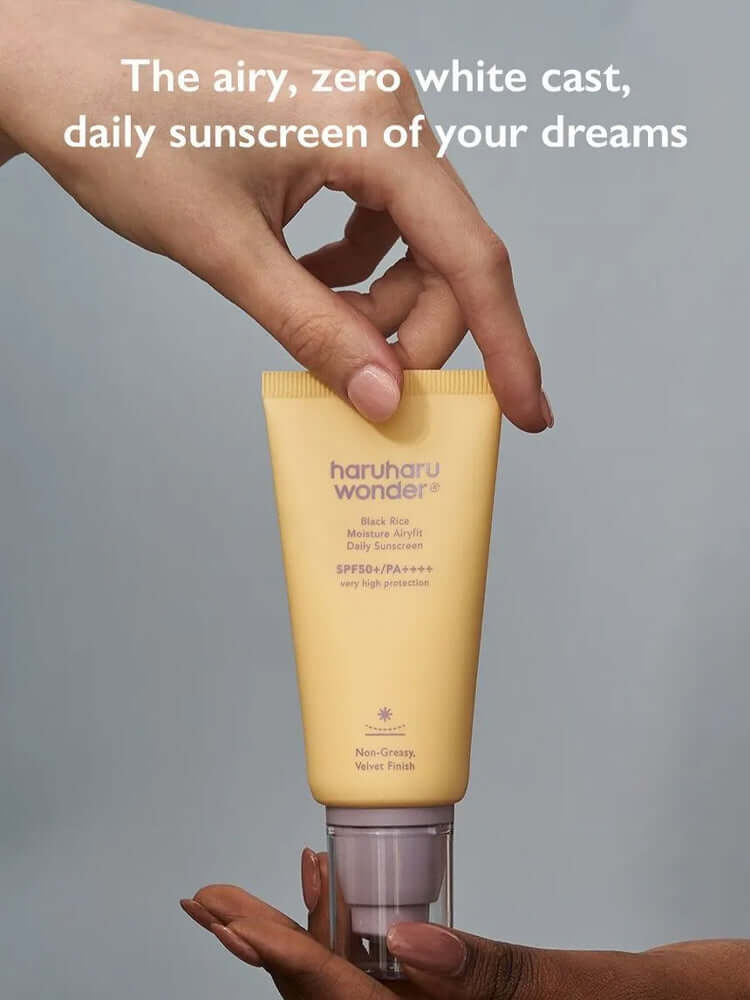 HARUHARU WONDER Black Rice Moisture Airyfit Daily Sunscreen 50ml in a hand with a soft focus and no white cast.