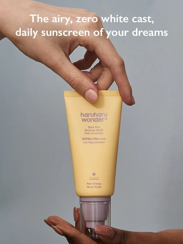 HARUHARU WONDER Black Rice Moisture Airyfit Daily Sunscreen 50ml in a hand with a soft focus and no white cast.