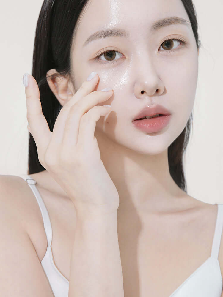 Woman applying HEVEBLUE Black Yuja Bean Lifting Auto Eye Cream 15ml on her face for glowing skin.