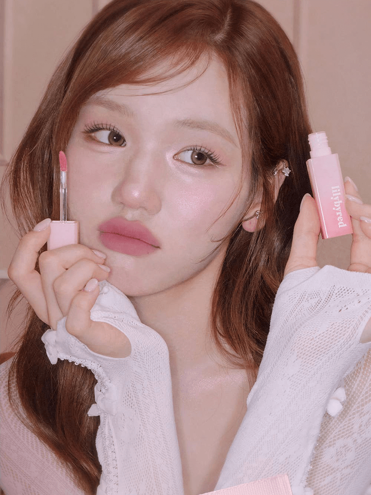 LILYBYRED Sweet Liar Milky Tint 4g in pink packaging, model applying soft milky red lip tint with fresh vitality.