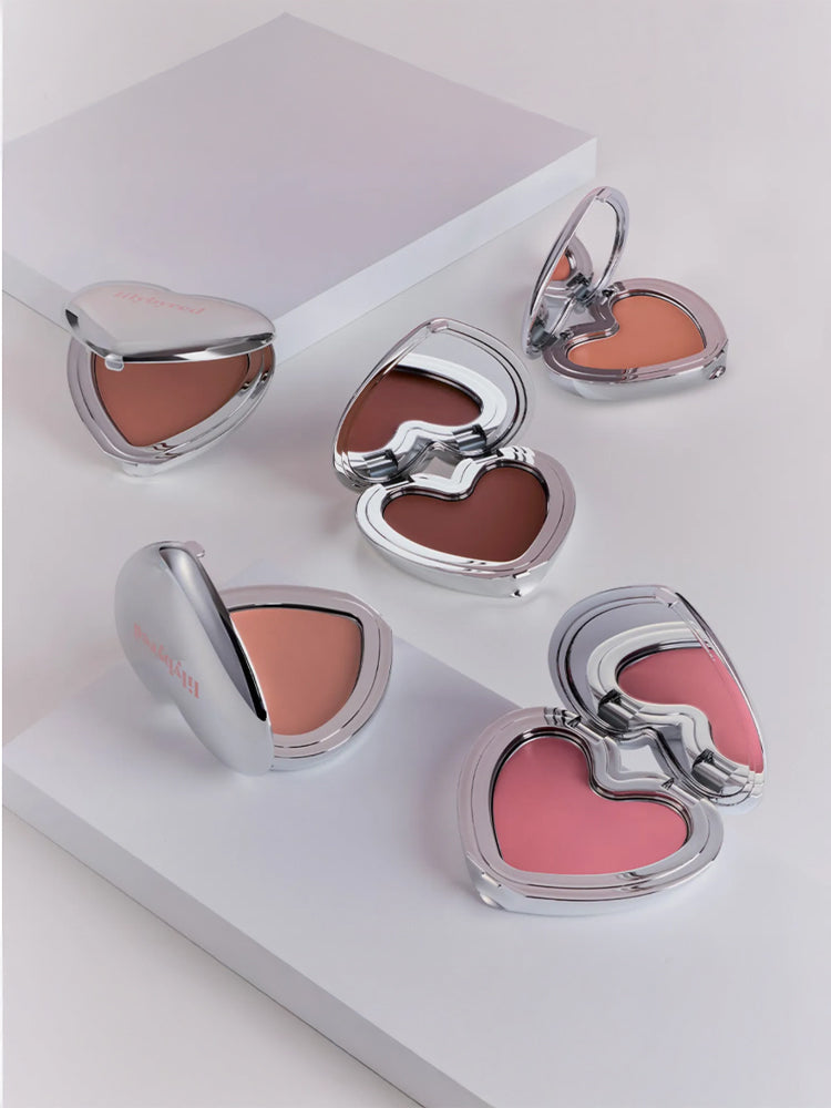 LILYBYRED Luv Beam Cheek Mousse 3.8g displayed in heart-shaped compacts on a white background.