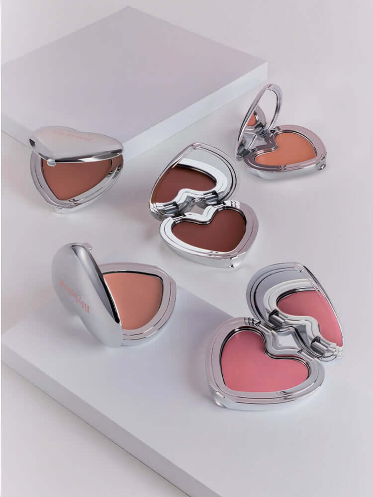 LILYBYRED Luv Beam Cheek Mousse 3.8g displayed in heart-shaped compacts on a white background.