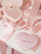 LILYBYRED [Pink Closet Edition] Luv Beam Glow Veil in heart-shaped packaging next to a shimmering powder.
