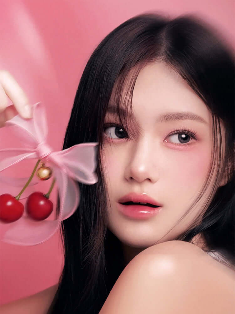 LILYBYRED Bloody Liar Coating Tint 4g model holding cherries on a pink background, showcasing a glossy lip look.
