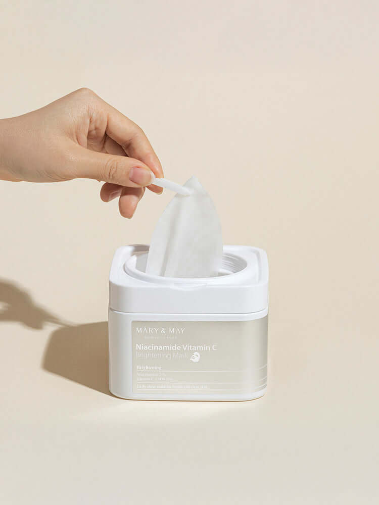 Hand pulling out a sheet from MARY&MAY Niacinamide Vitamin C Brightening Mask pack 400g 30EA.