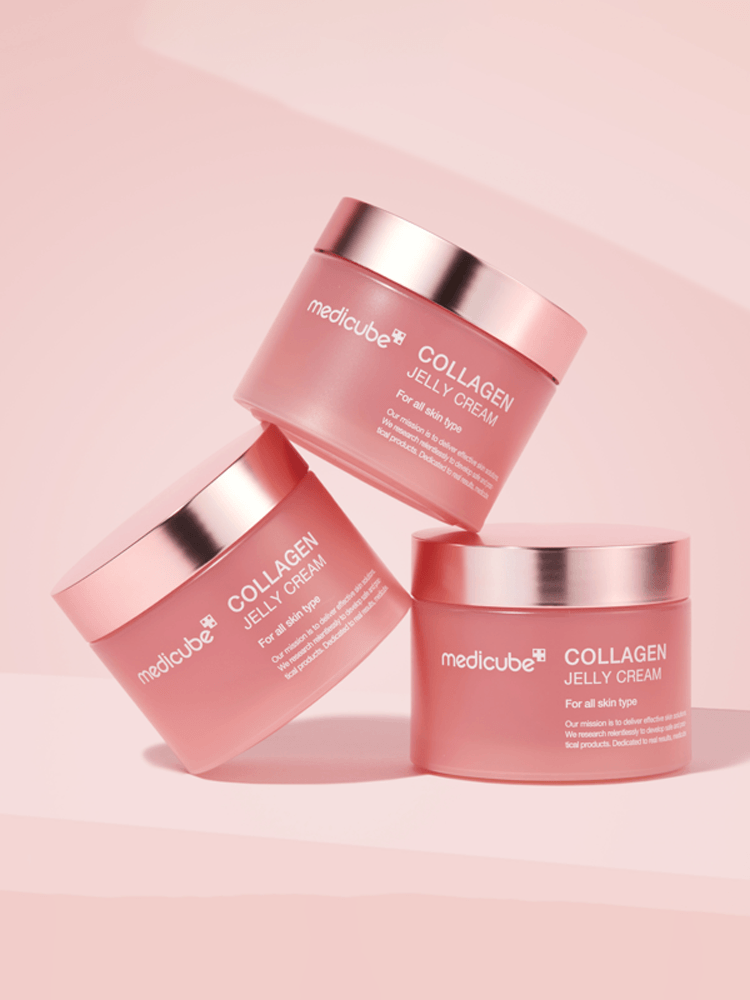 MEDICUBE Collagen Jelly Cream jars stacked on a pink background showcasing the product's elegant design.