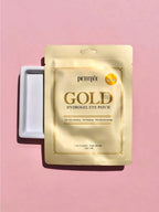 PETITFEE Gold Hydrogel Eye Patch 1.4g (Single Use - 1 pair) packaging on a pink background.
