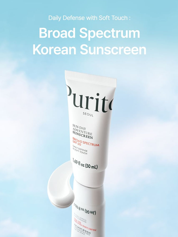 PURITO Sun Day Adventure Sunscreen 50ml tube with soft touch design against a blue sky background.