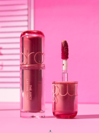 rom&nd The Juicy Lasting Tint Mini 1g bottle and applicator against a pink background.