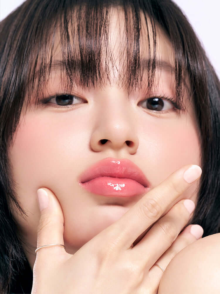 Close-up of a model showcasing glossy lips wearing romand juicy lasting tint, highlighting a fresh makeup look.