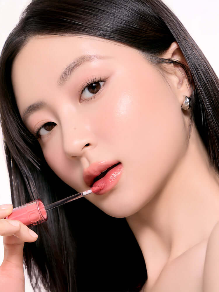 Model applying rom&nd The Juicy Lasting Tint 2.0 3.5g, showcasing its glossy finish and vibrant color.