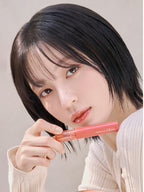 rom&nd Glasting Color Gloss Peach Sparkle showcased by a model holding the gloss, featuring a soft glow on her lips.