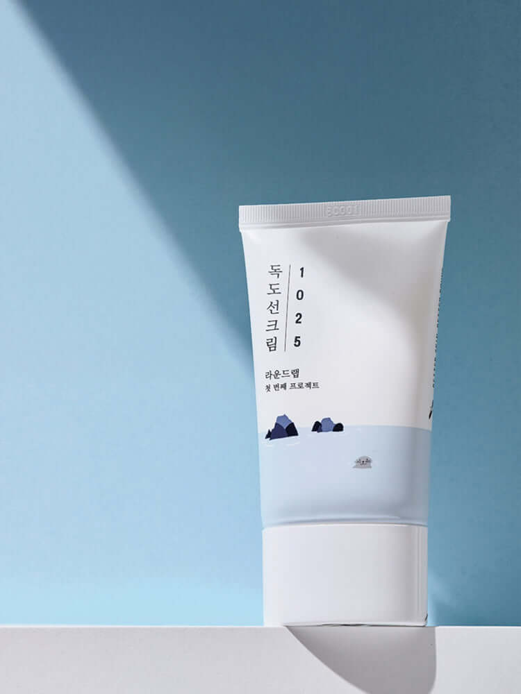 ROUND LAB 1025 Dokdo Sunscreen 50ml tube on a light blue background showcasing daily sun care for sensitive skin.