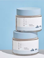 ROUND LAB 1025 Dokdo Light Cream 80ml jars stacked against a blue background.