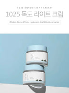 ROUND LAB 1025 Dokdo Light Cream 80ml displayed against a light blue background, showcasing its hydrating properties.