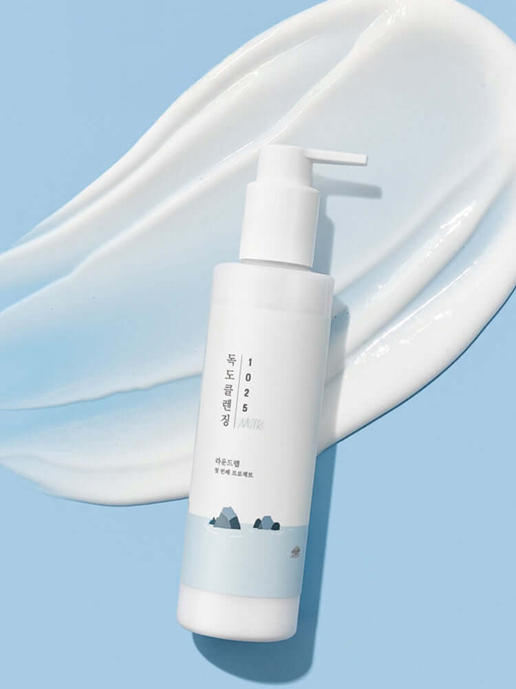 ROUND LAB 1025 Dokdo Cleansing Milk 200ml with creamy texture on a blue background.