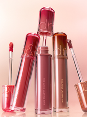 romnd The Juicy Lasting Tint NEW WARM collection featuring glossy lip tints in diverse colors and applicators.